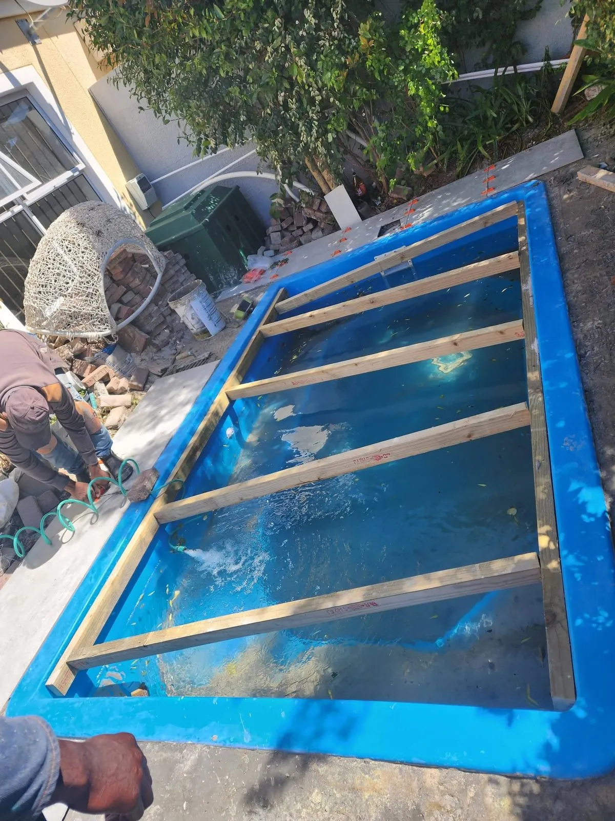 Fibreglass pool braced with timber while it fills